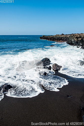 Image of beautiful view on ocean water and black lava sand