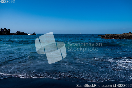 Image of beautiful view on ocean water and black lava sand