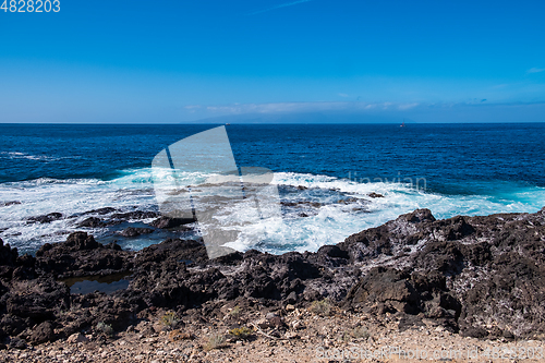 Image of beautiful view on ocean water and black lava sand