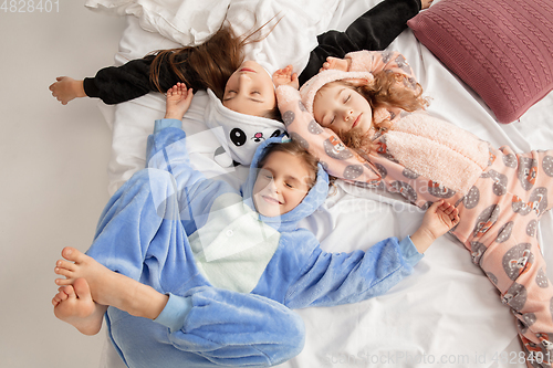 Image of Children in soft warm pajamas having party colored bright playing at home