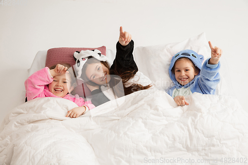 Image of Children in soft warm pajamas having party colored bright playing at home