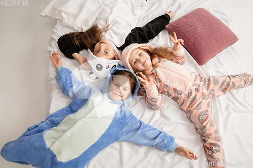 Image of Children in soft warm pajamas having party colored bright playing at home