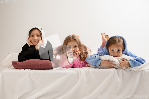 Image of Children in soft warm pajamas having party colored bright playing at home