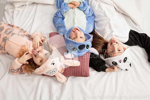 Image of Children in soft warm pajamas having party colored bright playing at home