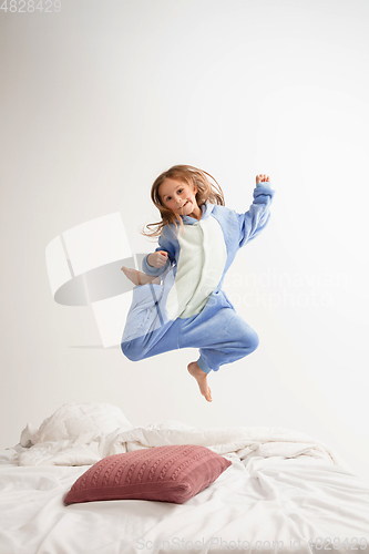 Image of Little girl in soft warm pajama having party colored bright playing at home