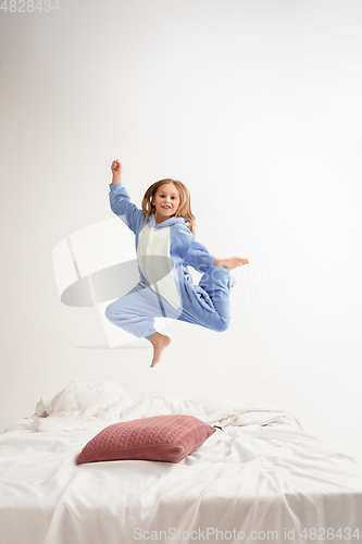 Image of Little girl in soft warm pajama having party colored bright playing at home