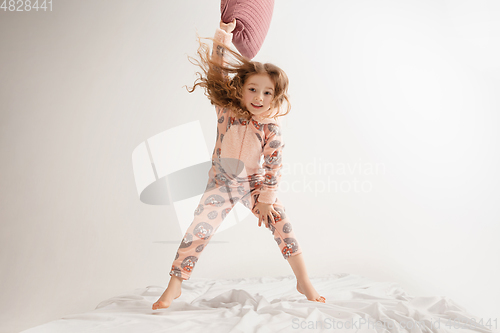 Image of Little girl in soft warm pajama having party colored bright playing at home