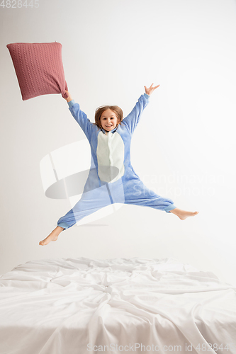 Image of Little girl in soft warm pajama having party colored bright playing at home