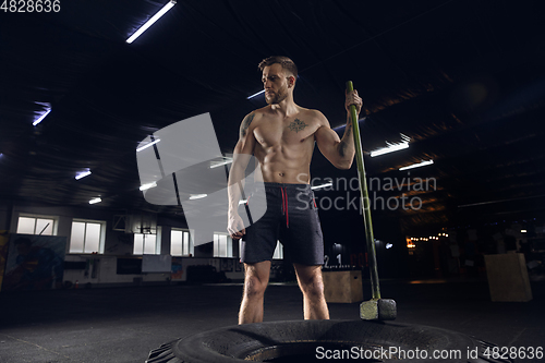 Image of Young healthy male athlete doing exercises in the gym