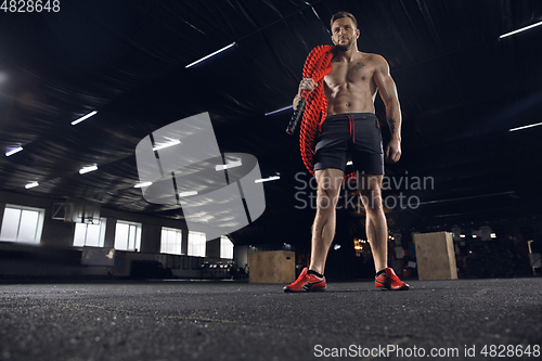 Image of Young healthy male athlete doing exercises in the gym