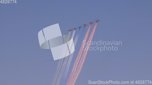 Image of stormtroopers planes Su-25 fly in sky leaving trail of smoke as tricolor Russian flag on training parade in honor of Great Patriotic War victory on May