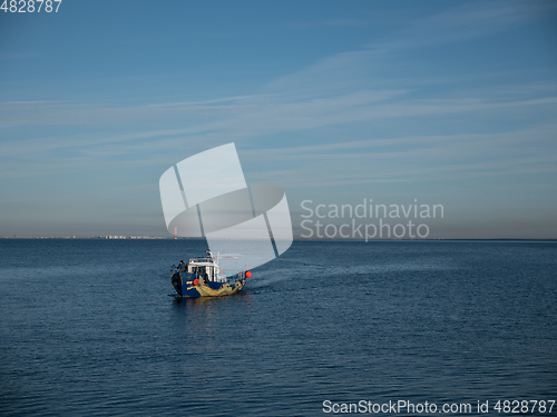 Image of Motor boat sailing away on the waves of the sea