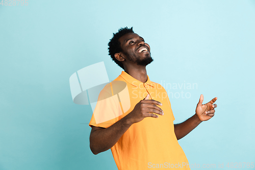 Image of African man\'s portrait isolated over blue studio background with copyspace