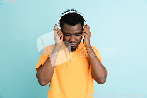 Image of African man\'s portrait isolated over blue studio background with copyspace