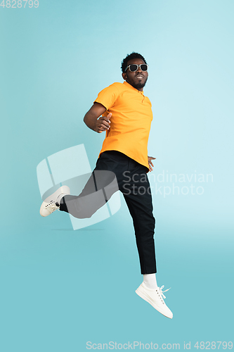 Image of Full length portrait of African young man isolated over blue studio background with copyspace