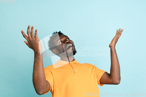 Image of African man\'s portrait isolated over blue studio background with copyspace