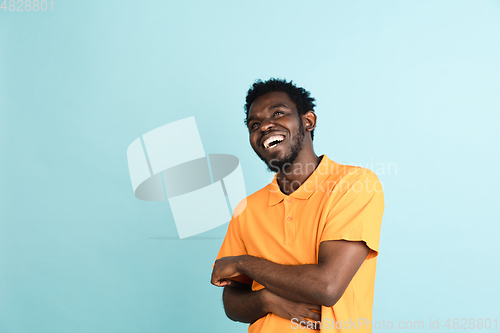Image of African man\'s portrait isolated over blue studio background with copyspace