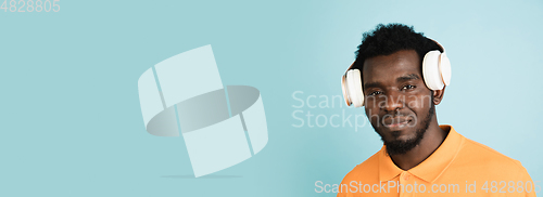 Image of African man\'s portrait isolated over blue studio background with copyspace