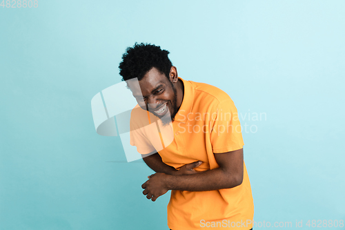 Image of African man\'s portrait isolated over blue studio background with copyspace