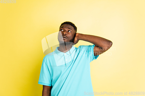 Image of Portrait of young African man isolated over yellow studio background with copyspace.
