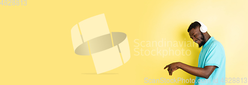 Image of Portrait of young African man isolated over yellow studio background with copyspace.