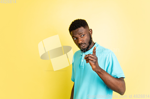 Image of Portrait of young African man isolated over yellow studio background with copyspace.