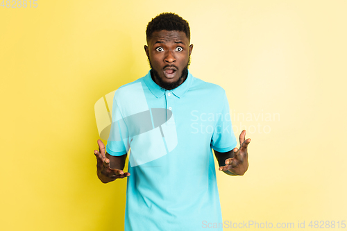 Image of Portrait of young African man isolated over yellow studio background with copyspace.
