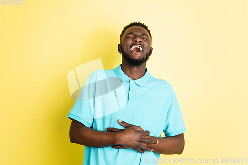 Image of Portrait of young African man isolated over yellow studio background with copyspace.