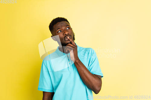 Image of Portrait of young African man isolated over yellow studio background with copyspace.