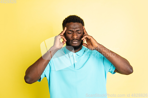 Image of Portrait of young African man isolated over yellow studio background with copyspace.