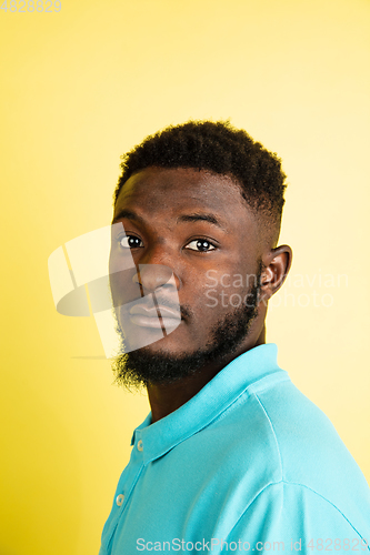 Image of Portrait of young African man isolated over yellow studio background with copyspace.