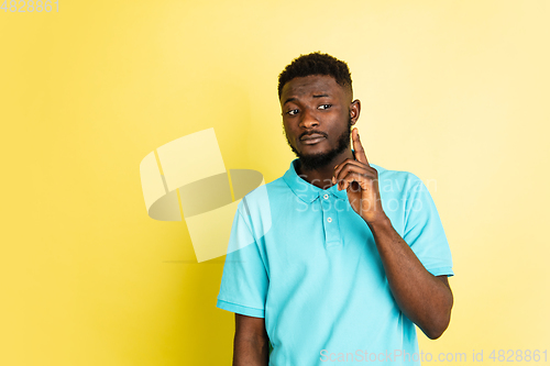 Image of Portrait of young African man isolated over yellow studio background with copyspace.