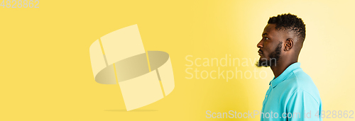 Image of Portrait of young African man isolated over yellow studio background with copyspace.