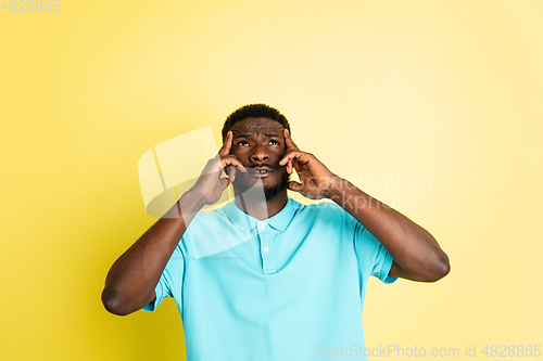 Image of Portrait of young African man isolated over yellow studio background with copyspace.