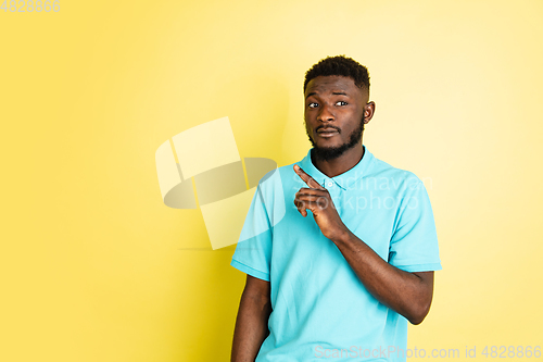 Image of Portrait of young African man isolated over yellow studio background with copyspace.