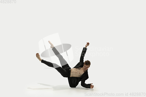 Image of Man in casual style clothes jumping and dancing isolated on white background. Art, motion, action, flexibility, inspiration concept. Flexible caucasian ballet dancer.