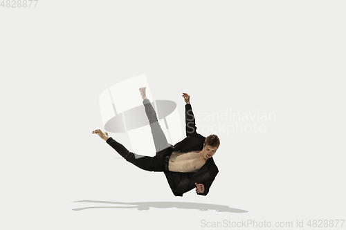 Image of Man in casual style clothes jumping and dancing isolated on white background. Art, motion, action, flexibility, inspiration concept. Flexible caucasian ballet dancer.