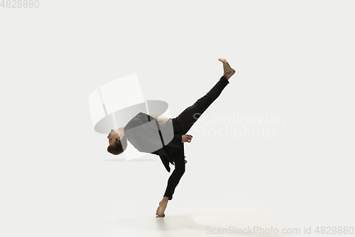 Image of Man in casual style clothes jumping and dancing isolated on white background. Art, motion, action, flexibility, inspiration concept. Flexible caucasian ballet dancer.