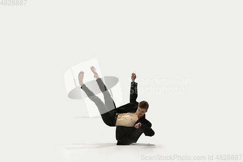 Image of Man in casual style clothes jumping and dancing isolated on white background. Art, motion, action, flexibility, inspiration concept. Flexible caucasian ballet dancer.