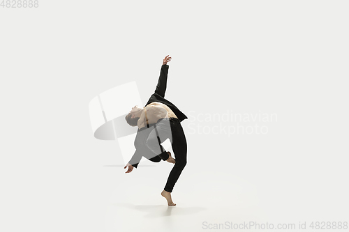 Image of Man in casual style clothes jumping and dancing isolated on white background. Art, motion, action, flexibility, inspiration concept. Flexible caucasian ballet dancer.