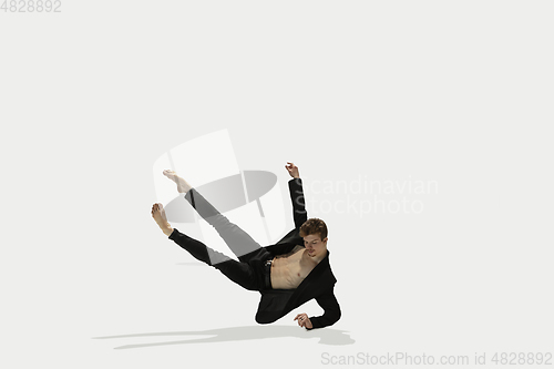 Image of Man in casual style clothes jumping and dancing isolated on white background. Art, motion, action, flexibility, inspiration concept. Flexible caucasian ballet dancer.