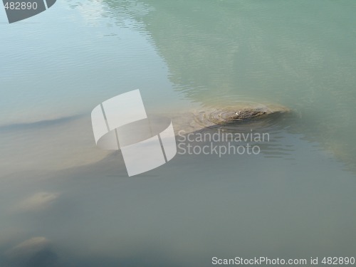 Image of grey polished rocks and green river water