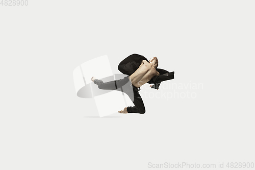 Image of Man in casual style clothes jumping and dancing isolated on white background. Art, motion, action, flexibility, inspiration concept. Flexible caucasian ballet dancer.