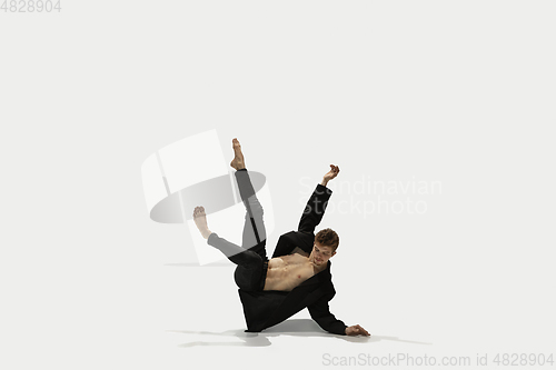 Image of Man in casual style clothes jumping and dancing isolated on white background. Art, motion, action, flexibility, inspiration concept. Flexible caucasian ballet dancer.