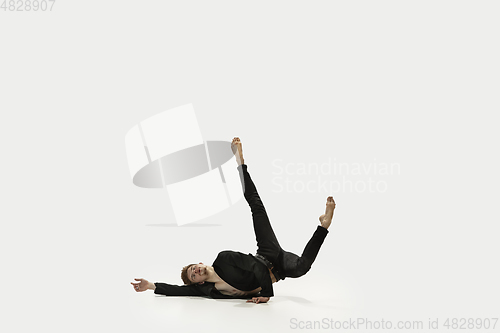 Image of Man in casual style clothes jumping and dancing isolated on white background. Art, motion, action, flexibility, inspiration concept. Flexible caucasian ballet dancer.