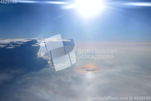 Image of Wonderful view from window of plane in morning sun over clouds