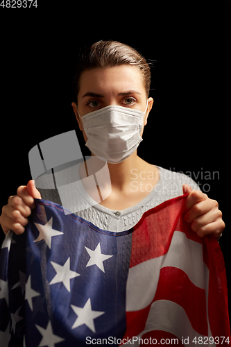 Image of sick woman in face mask holding flag of america