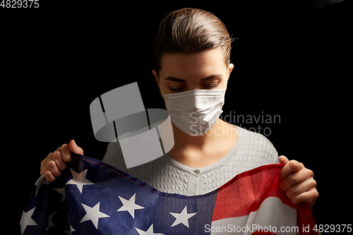 Image of sick woman in face mask holding flag of america