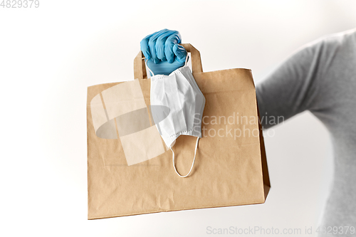 Image of woman with shopping bag, face mask and gloves