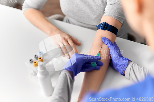 Image of doctor taking blood for test from patient's hand